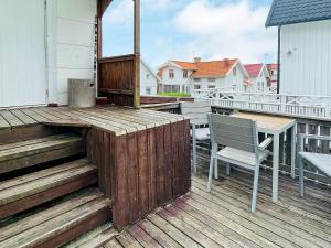 eine Holzterrasse mit einem Tisch und Stühlen auf dem Balkon in der Unterkunft Holiday home ÅSTOL 