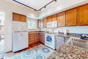 a kitchen with white appliances and wooden cabinets at Sweet Retreat at Sweet Water in Hailey