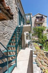 a green stairway next to a building with a stone wall at Apartment Silvana in Split
