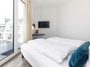 een witte slaapkamer met een bed en een raam bij Apartment Wendtorf XXVII in Wendtorf