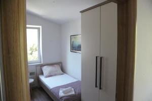 1 dormitorio pequeño con 1 cama y armario en Apartments Sonne 2, en Crikvenica