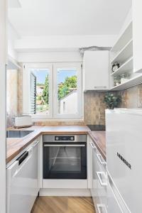 a kitchen with white cabinets and a window at Apartment Silvana in Split