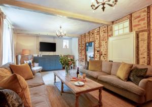 a living room with a couch and a table at Church Farm in Halesworth