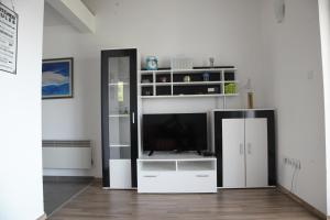 una sala de estar con TV y un centro de entretenimiento blanco en Apartments Sonne 2, en Crikvenica