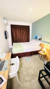 a hotel room with a bed and a desk with a laptop at URB Hotel in Fortaleza