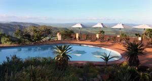 una piscina con sedie e ombrelloni su una montagna di Pakamisa Private Game Reserve a Pongola