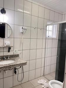 a bathroom with a shower and a sink and a toilet at Pousada do Vento in Campos do Jordão