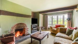 a living room with a fireplace and a couch at Woodside 