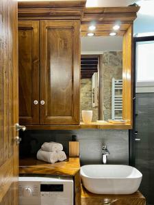 a bathroom with a sink and a microwave at The Stonewall House - at the old town of Samos in Vathý