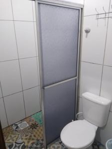 a bathroom with a toilet and a shower stall at Central 2 - Pousada in Uruguaiana
