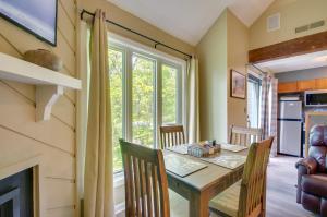 a dining room with a table and chairs and a fireplace at 2nd-Floor Condo with Community Pool Access! in Lyndhurst