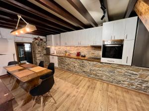 eine Küche mit einem Holztisch und einem Esszimmer in der Unterkunft The Stonewall House - at the old town of Samos in Vathý