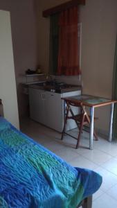a kitchen with a table and a desk in a room at Valta's Room 2 in Paleros
