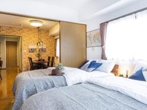 a bedroom with two beds and a dining room at AirStay Horikiri 402 - Vacation STAY 45433v in Tokyo