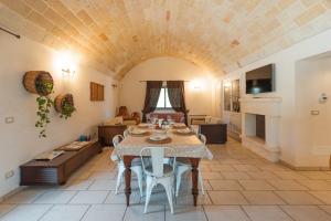 una sala de estar con una mesa y un sofá en Trulli Olea with Pool, en San Vito dei Normanni