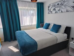 a bedroom with a large bed with blue curtains at Benjamin Gardens Holiday Home in Great Driffield