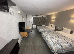 um quarto de hotel com duas camas e uma mesa em Motel 6-Sallisaw, OK em Sallisaw