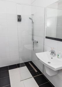 a white bathroom with a shower and a sink at The Old Townhouse II in Krosno