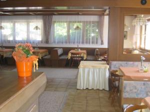 ein Speisesaal mit Tischen und Stühlen in einem Restaurant in der Unterkunft Pension Wolf in Steindorf am Ossiacher See