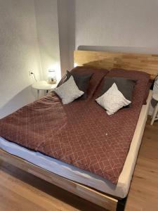 Apartment Mirabelle 3 في Püttlingen: سرير مع اللوح الأمامي الخشبي والوسائد عليه