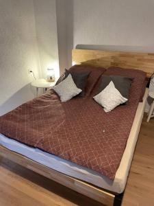 a bed with a wooden headboard and pillows on it at Apartment Mirabelle 3 in Püttlingen