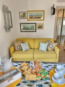 uma sala de estar com um sofá e uma mesa com comida em La finestra sul mare em La Spezia