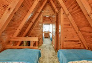 a bedroom with two beds in a wooden attic at Domki letniskowe Zakątek Kołobrzeg in Kołobrzeg