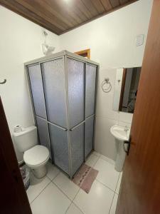 a bathroom with a shower with a toilet and a sink at Central 2 - Pousada in Uruguaiana