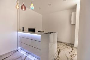 a white kitchen with a counter in a room at Hôtel Mare E Monti in Piana