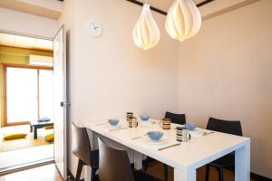 een eetkamer met een witte tafel en stoelen bij Nagaetsu - Vacation STAY 47717v in Kyoto
