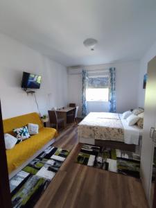 a bedroom with a bed and a couch and a tv at Apartment Palma in Zadar