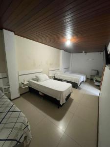 sypialnia z 2 łóżkami i drewnianym sufitem w obiekcie Central 2 - Pousada w mieście Uruguaiana