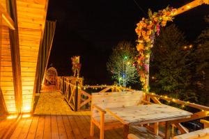 a wooden deck with a wooden bench on a porch at night at Aliki Bungalow in Cayeli