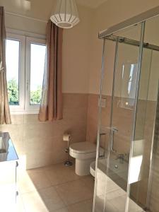 a bathroom with a toilet and a glass shower at Villa Mar in Noto Marina