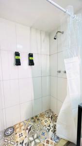 a bathroom with a shower and a tile floor at URB Hotel in Fortaleza