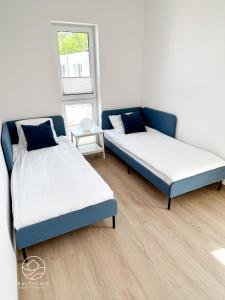 a room with two beds and a window at Apartamenty Bałtyckie - Luxoro Park in Ustka