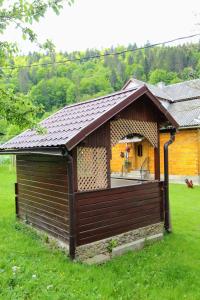 a small building with a roof on the grass at Багрівчанка in Yaremche