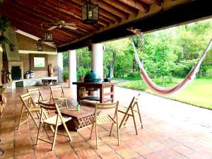 un patio con mesa, sillas y hamaca en Hotel boutique Arteaga, en Arteaga
