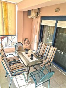 un tavolo e sedie su un balcone con tavolo di Nostos House a Nea Anchialos