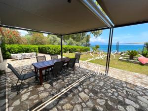 a table and chairs on a patio with a view of the ocean at S S HOME in Petalidi