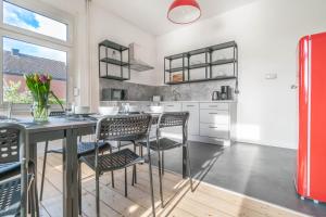 a kitchen with a table and chairs and a red refrigerator at - WORKERS FAVORITE - Großes Haus mit 8 Einzelbetten und tollem Garten in Wesel