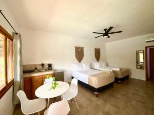 une chambre d'hôtel avec un lit, une table et des chaises dans l'établissement La Casa del Sol Holbox, à Holbox