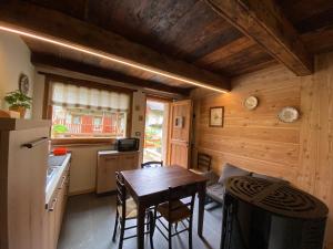 a kitchen with a table and chairs in a cabin at L'Oasi di Sodani1 in Sampeyre