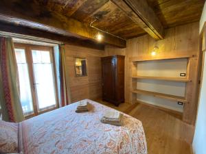 a bedroom with a bed in a room with wooden walls at L'Oasi di Sodani1 in Sampeyre