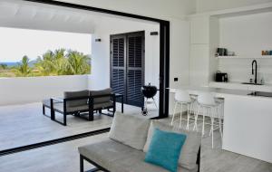 a living room with a couch and a kitchen at Blue Bay Penthouse REEF 5, BEACH GOLF POOL DIVE with OCEAN View in Sint Michiel