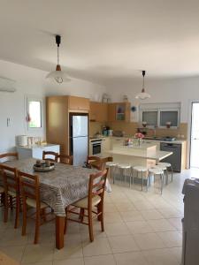 a kitchen and dining room with a table and chairs at Villa Melita Seafront in Pefki