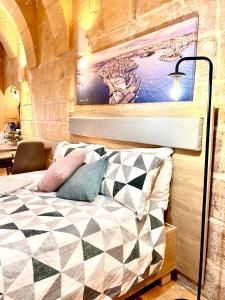 バレッタにあるMCC Suites Vallettaのベッドルーム1室(ベッド1台付)が備わります。壁には絵画が飾られています。