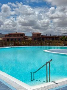 a large blue swimming pool in front of a building at Villa Aloe in Lajares