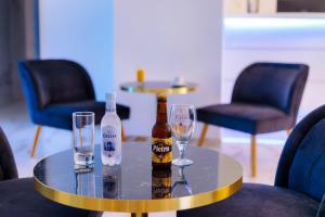 - deux bouteilles et des verres sur une table avec des chaises dans l'établissement Hôtel Mare E Monti, à Piana