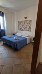 a bedroom with a blue bed with towels on it at COLORI DEL MARE FAVIGNANA CENTRO in Favignana